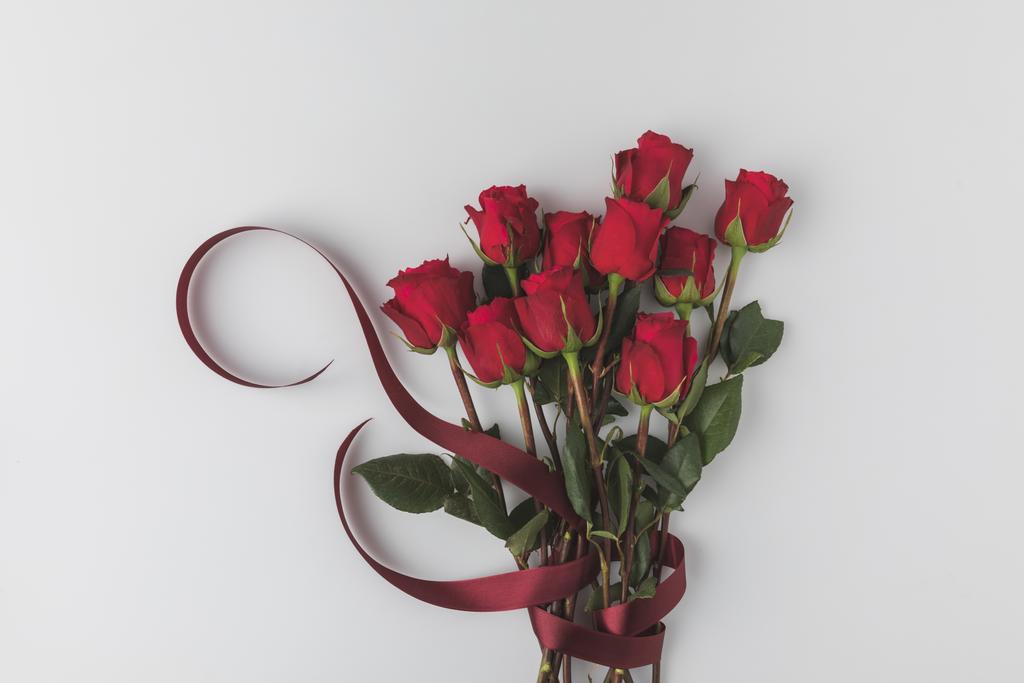 верхний вид красивых красных роз с лентой изолированы на белом, День святого Валентина концепции
 - Фото, изображение