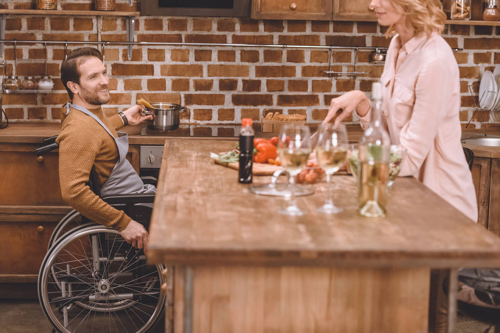 recortado tiro de mujer con hombre en silla de ruedas cocinar cena juntos en casa
  - Foto, imagen
