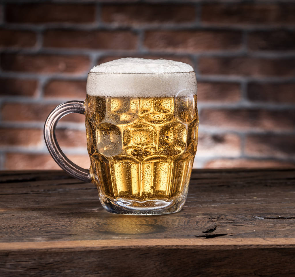 Frosted mug of beer on the wooden table. - Photo, Image