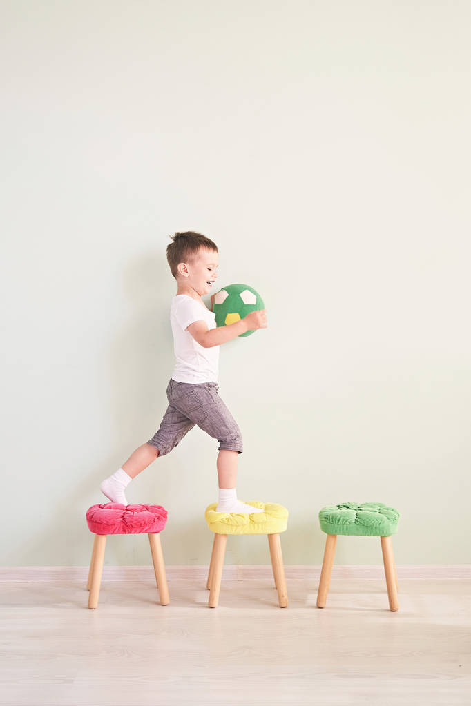 Full length portrait of a child with a soccer ball isolated in home - Photo, Image