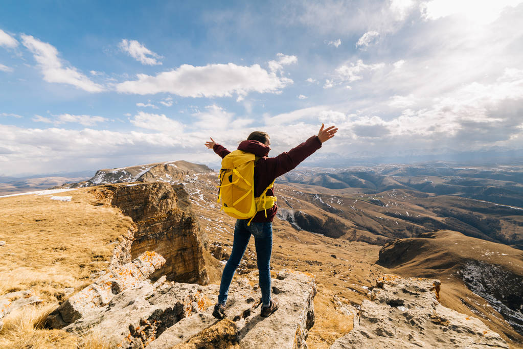 ενεργή κοπέλα που ταξιδεύει κατά μήκος της κορυφογραμμής του Καυκάσου με ένα κίτρινο σακίδιο - Φωτογραφία, εικόνα