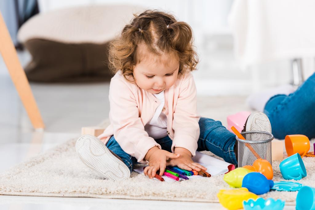 επιλεκτική εστίαση από μικρό παιδί παίζει με πολύχρωμους μαρκαδόρους στο σπίτι - Φωτογραφία, εικόνα