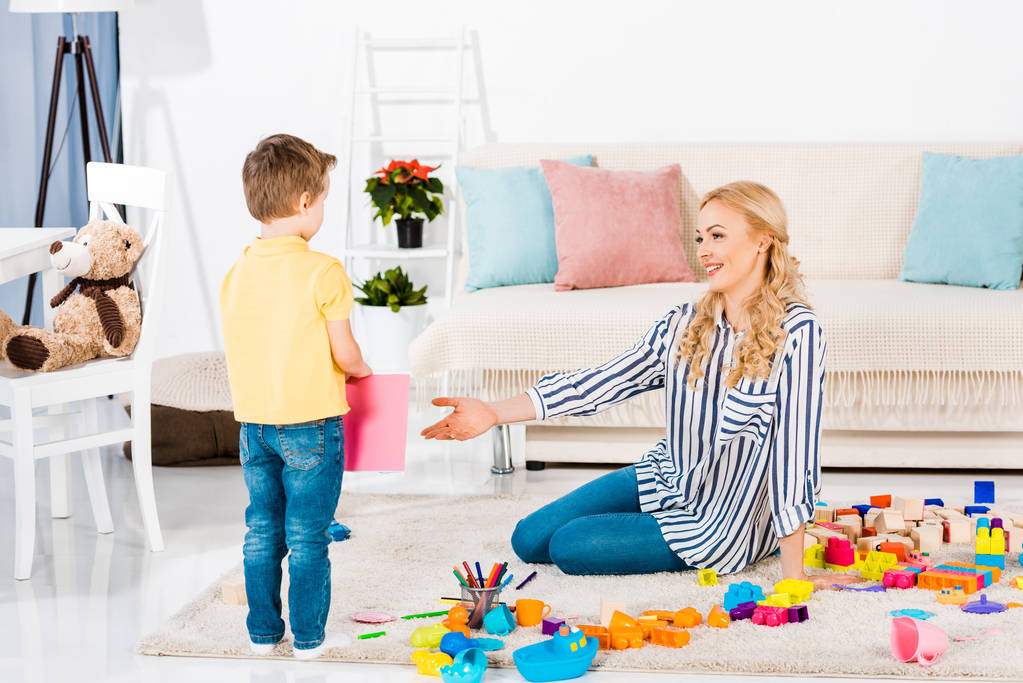μητέρα και ο μικρός γιος παίζει με τα παιχνίδια μαζί στο πάτωμα στο σπίτι - Φωτογραφία, εικόνα
