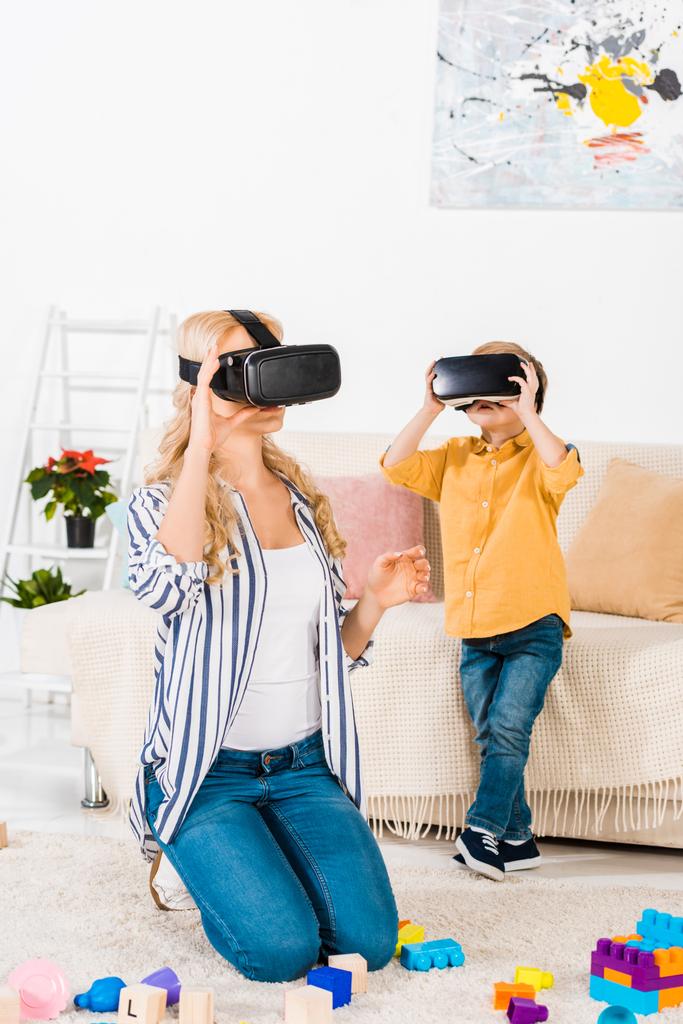 beautiful mother and son using virtual reality headsets together at home  - Photo, Image