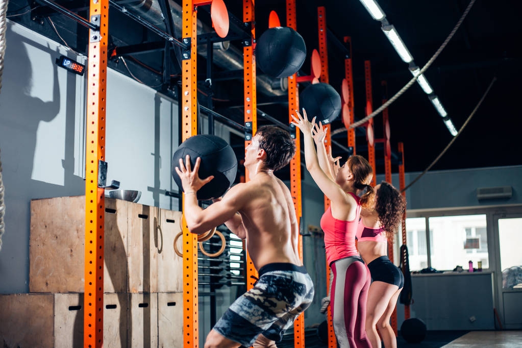 Fitness-, Sport- und Bewegungskonzept - Menschen mit Medizinbällen trainieren im Fitnessstudio - Foto, Bild