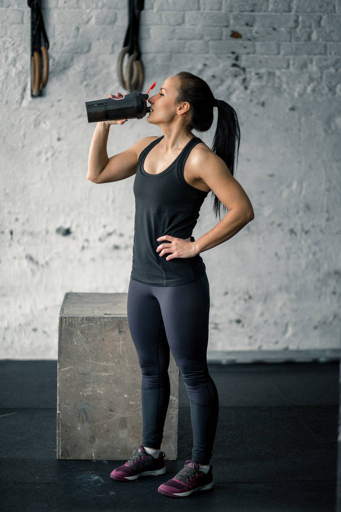 Meisje drinkwater in de sportschool na workout - Foto, afbeelding