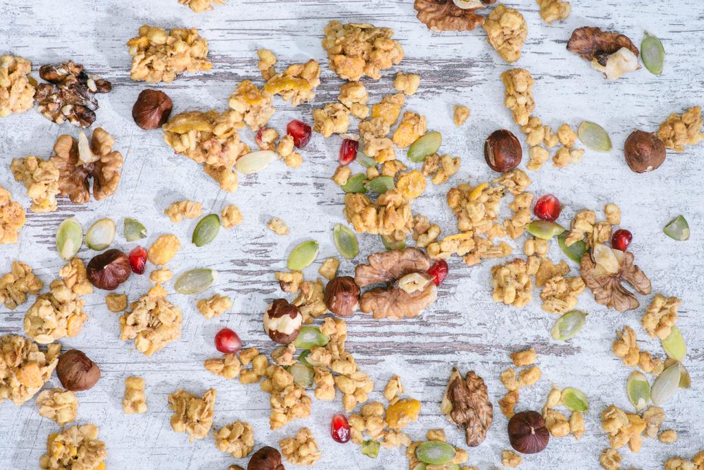 top view of scattered granola with nuts on grungy tabletop - Photo, Image