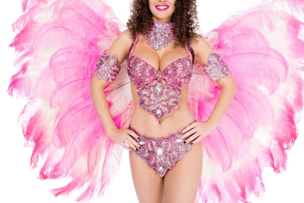 ピンクの羽は、白で隔離、カーニバルの衣装でポーズをとる女の子のトリミング ビュー - 写真・画像