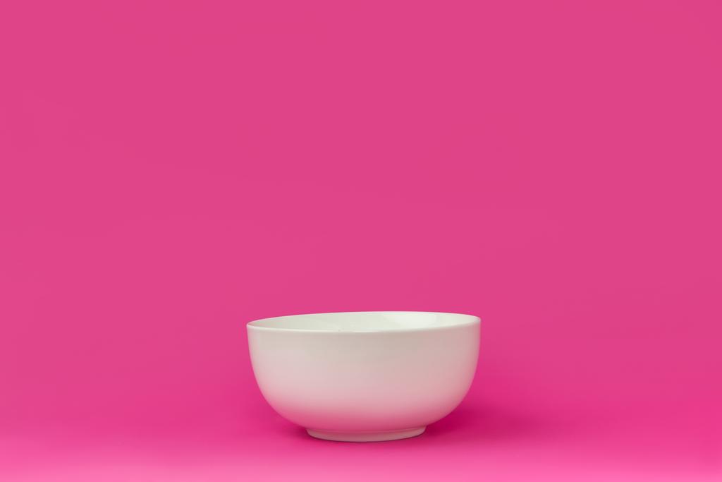 крупным планом вид одной пустой белой миски, готовой к завтраку, изолированной на розовом фоне
  - Фото, изображение