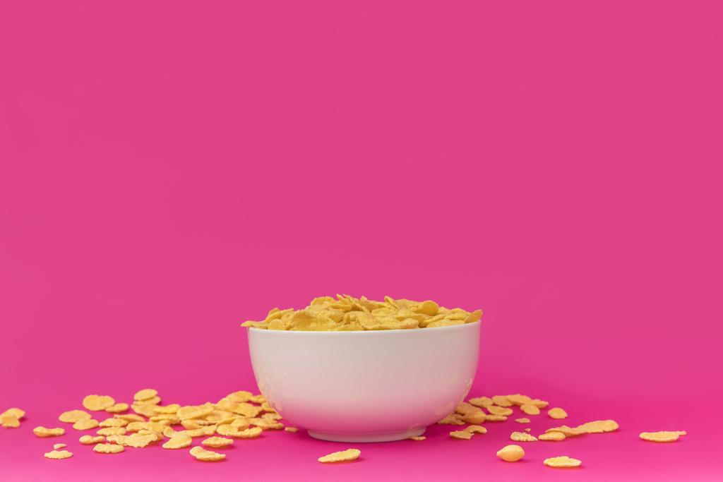 vue rapprochée du bol blanc avec de savoureux flocons de maïs croquants sur rose
  - Photo, image