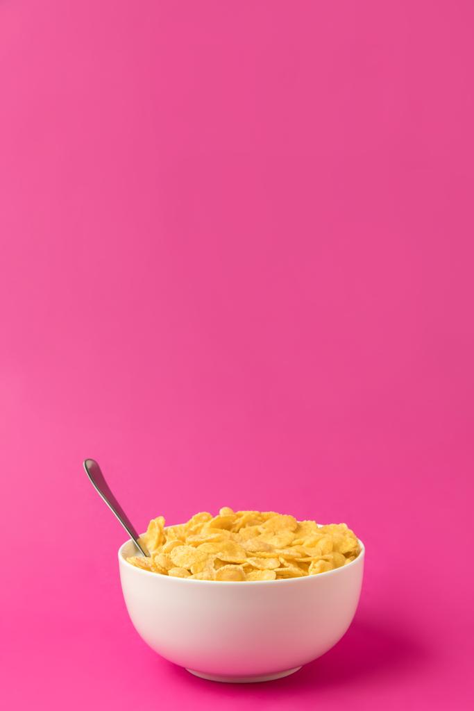 egészséges reggeli ízletes kukorica pehely és tej-tál, kanál elszigetelt rózsaszín  - Fotó, kép