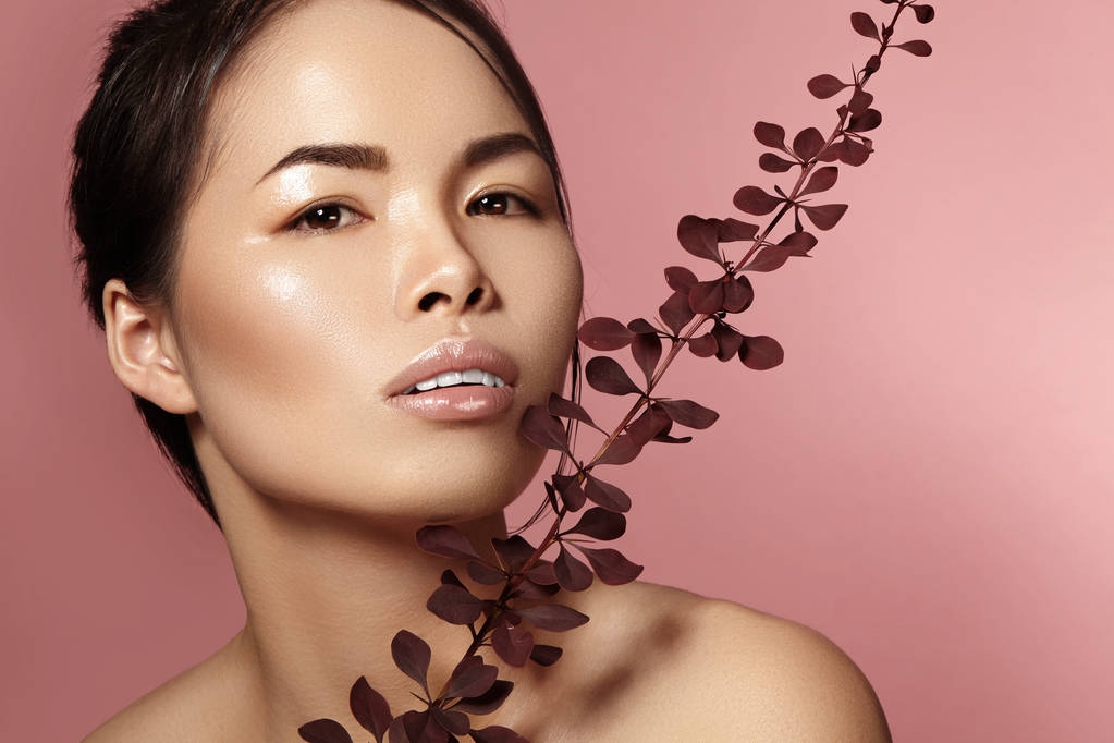 Piękne Azjatki kobiety z świeży makijaż dzienny. Wietnamski piękna dziewczyna w spa leczenia z zielony liści w pobliżu twarzy - Zdjęcie, obraz