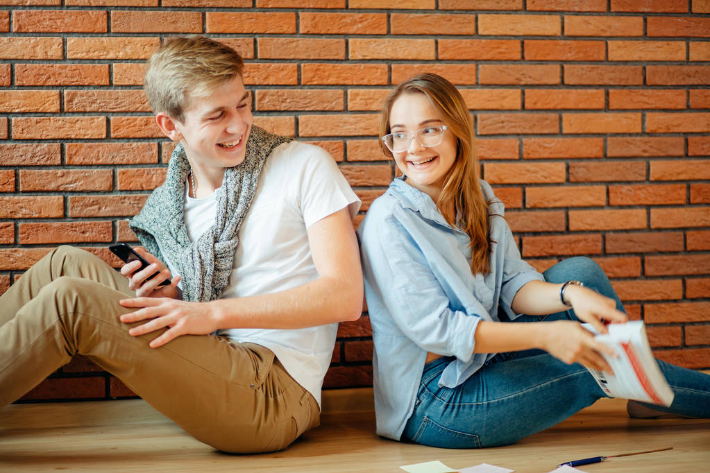 junges Paar liest zu Hause ein Buch auf Holzboden - Foto, Bild