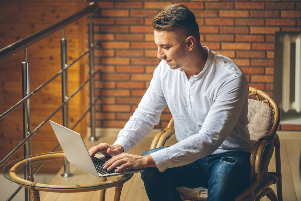 muž sedí doma a pracovat na notebooku. muž z podkroví domácí kancelář - Fotografie, Obrázek
