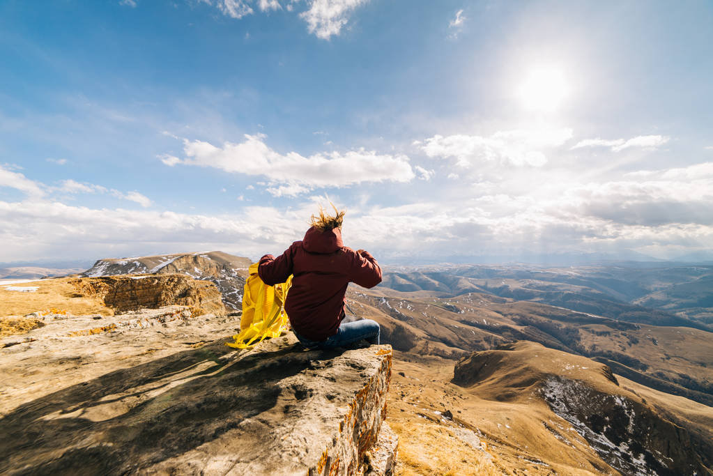 genç kız sağlıklı ve aktif bir yaşam tarzı olur, sarı bir sırt çantası ile bir dağ kenarında oturur - Fotoğraf, Görsel