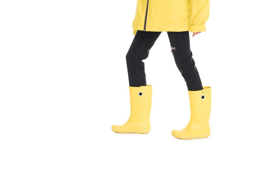 gedeeltelijke weergave van vrouw in gele regenjas en regen laarzen geïsoleerd op wit - Foto, afbeelding