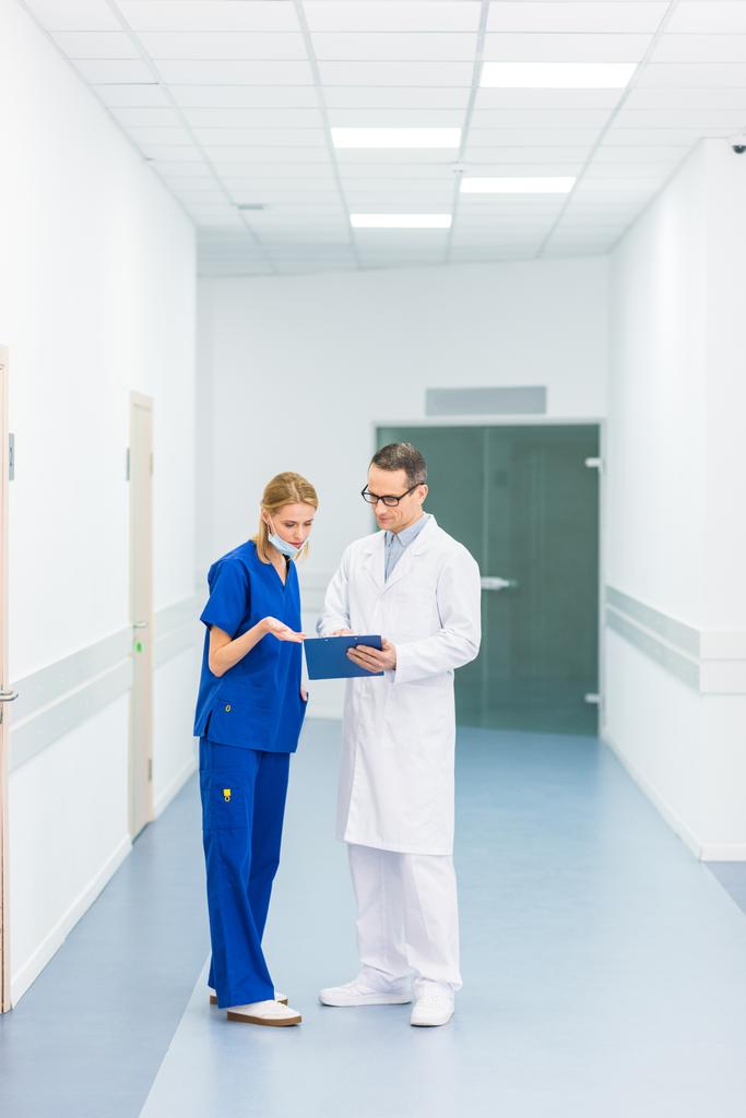 doctor en bata blanca y cirujana mujer discutiendo el diagnóstico en el hospital
 - Foto, Imagen
