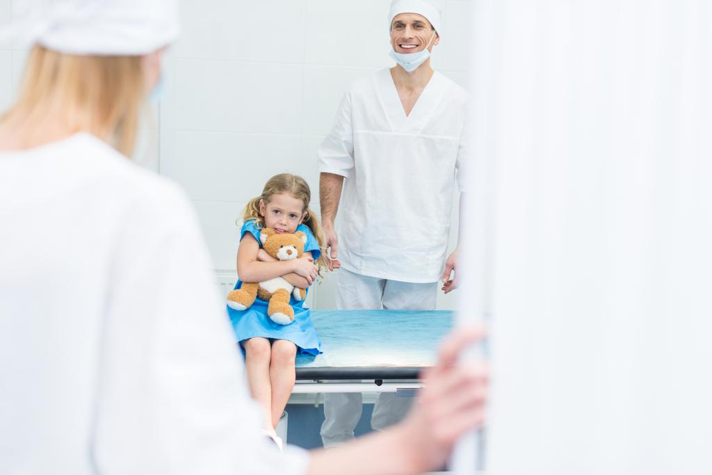 médecins préparant enfant effrayé pour la chirurgie en salle d'opération
 - Photo, image