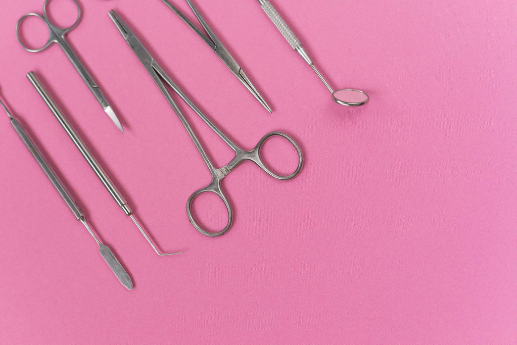 a rózsaszín felszínen vannak orvosi Fogászati műszerek - Fotó, kép
