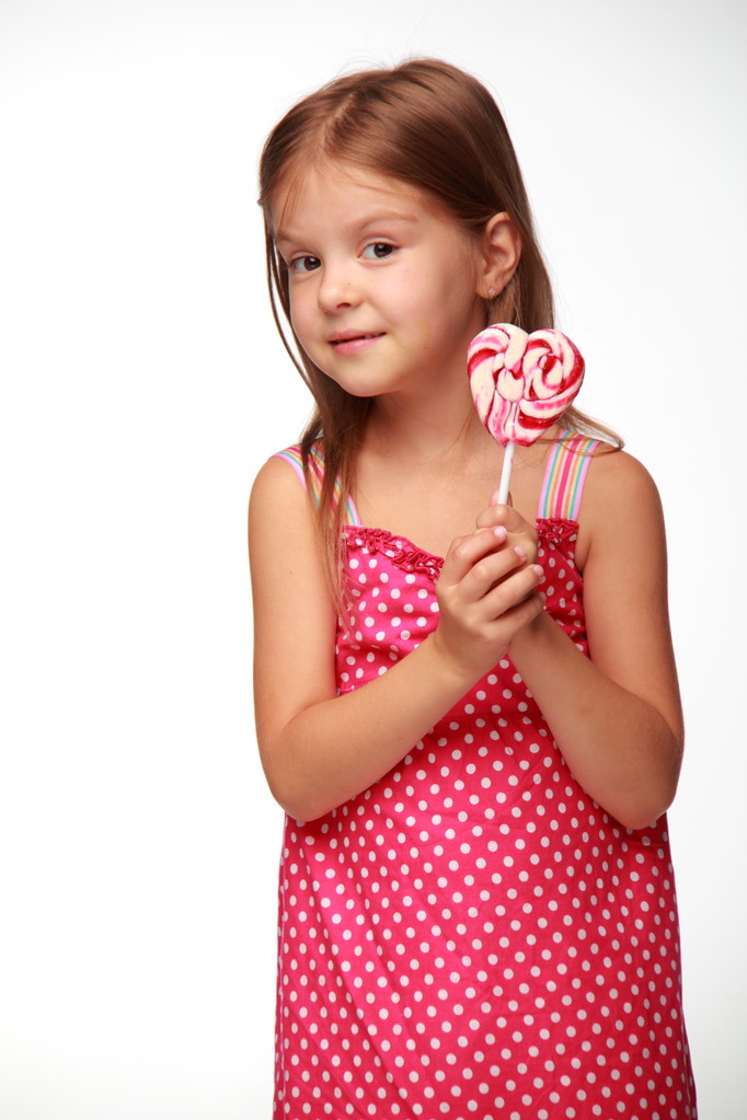Маленькая девочка в розовом платье с леденцом
 - Фото, изображение