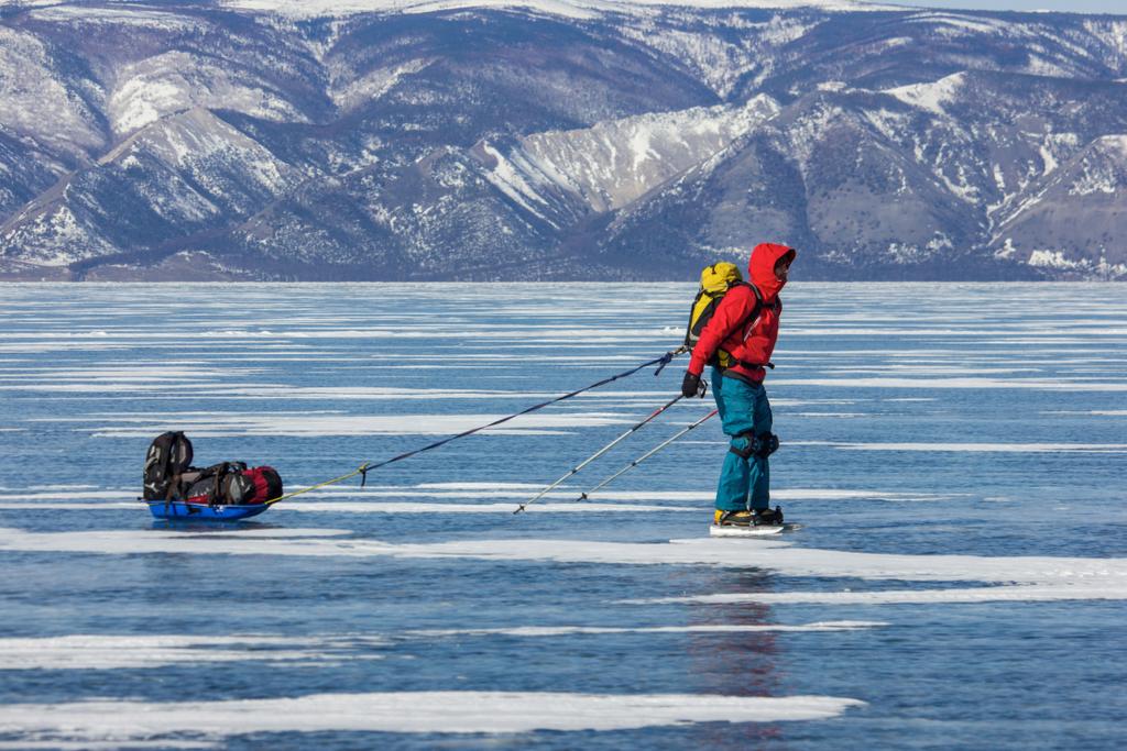 senderista masculino con mochila de pie sobre la superficie del agua de hielo, Rusia, lago baikal
  - Foto, Imagen