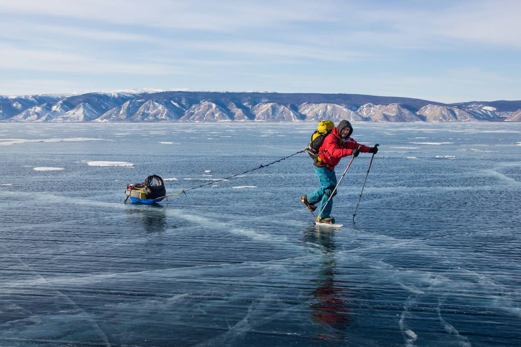 αρσενικό πεζοπόρος με σακίδιο περπάτημα στο νερό πάγου επιφάνεια,, Ρωσία, λίμνη Βαϊκάλη   - Φωτογραφία, εικόνα