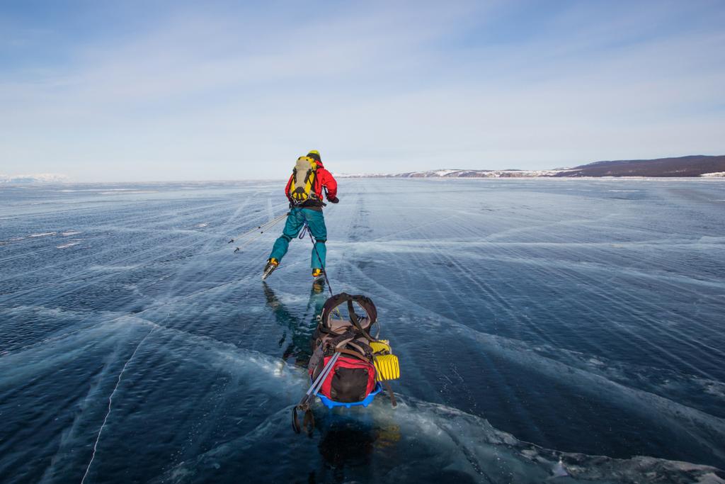 αρσενικό πεζοπόρος με σακίδιο περπάτημα στο νερό πάγου επιφάνεια, τη Ρωσία, λίμνη Βαϊκάλη  - Φωτογραφία, εικόνα