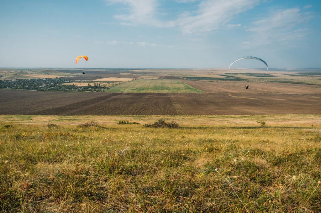 Paracaidistas que se deslizan en el cielo azul sobre el paisaje escénico de Crimea, Ucrania, mayo 2013
 - Foto, imagen