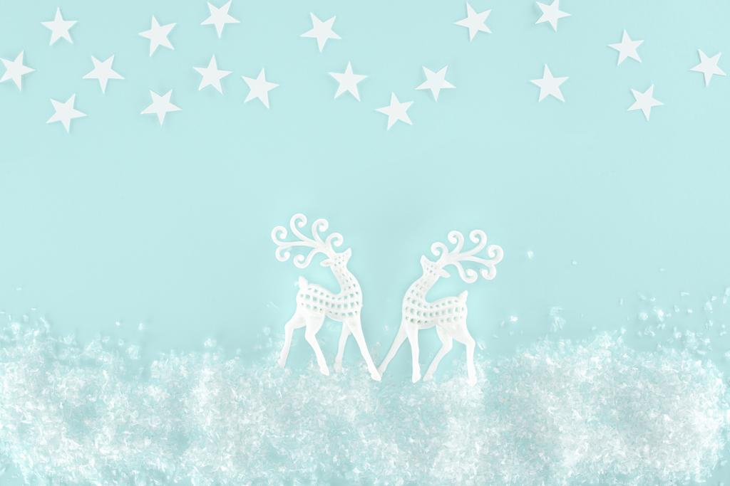 christmas background with decorative snow, stars and paper deer, isolated on light blue - Photo, Image