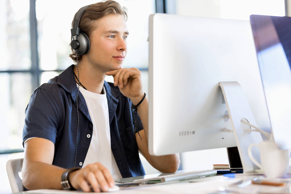 Young man in the office with headphones - Photo, Image