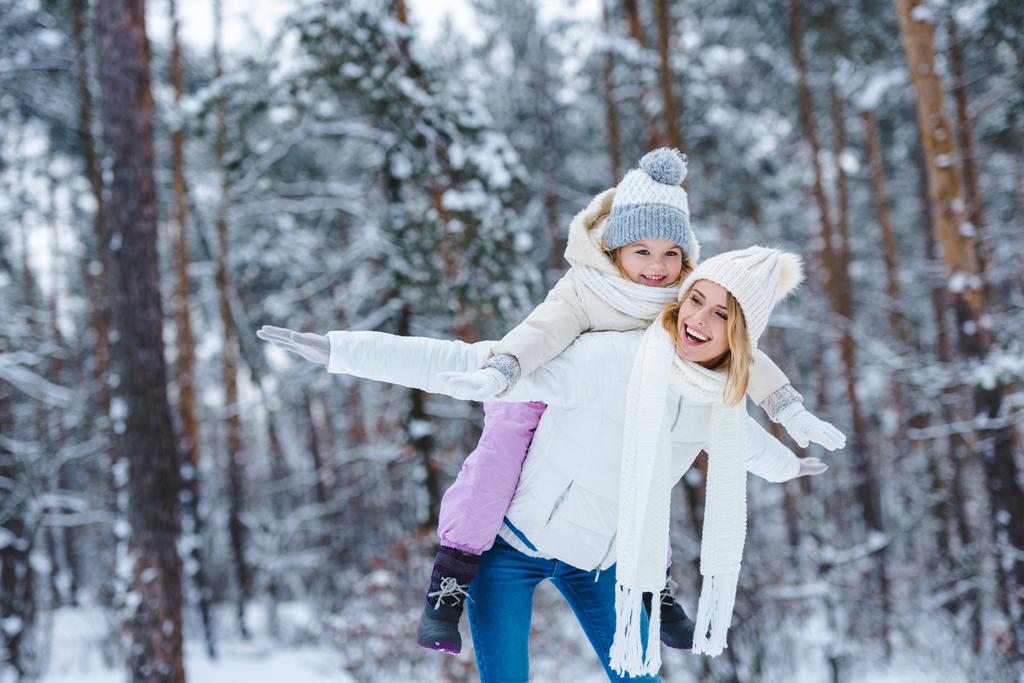 陽気な母と小さな子供の冬の公園で一緒に便乗 - 写真・画像