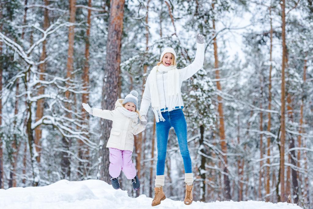 Mutter und kleine Tochter amüsieren sich gemeinsam im Winterpark - Foto, Bild