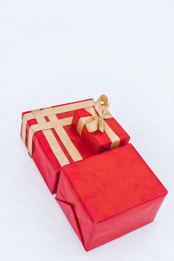 крупним планом червоні подарункові коробки з золотими стрічками ізольовані на сірому
  - Фото, зображення