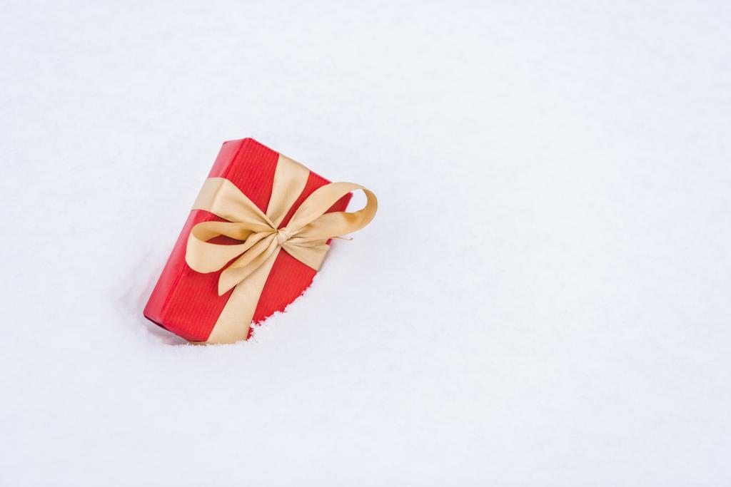 雪の中で金色のリボンと赤いギフト ボックスのクローズ アップ ビュー  - 写真・画像