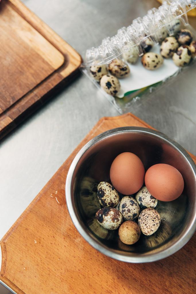 felülnézet csirke és fürj tojás fém tálban a konyha - Fotó, kép