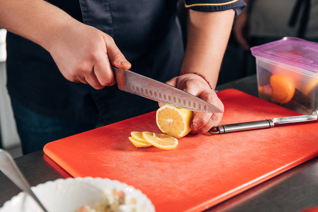 обрізаний знімок шеф-кухаря нарізаючи лимон в ресторані
 - Фото, зображення