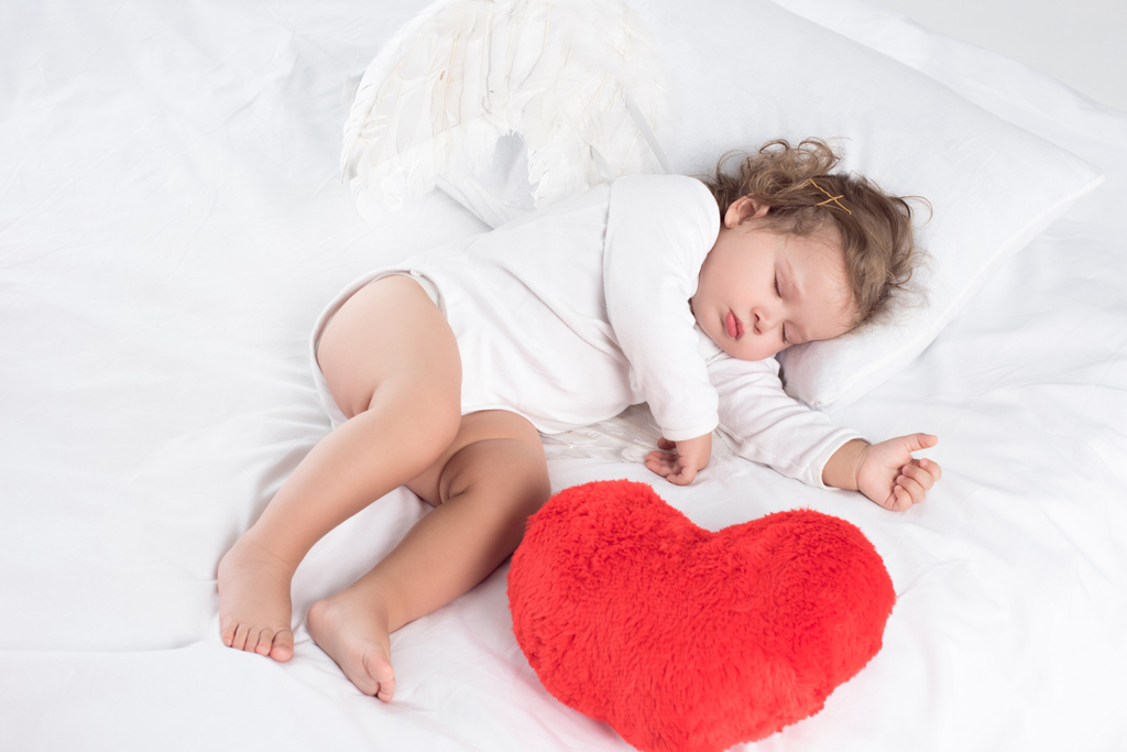 Kleines Baby mit Herz im Bett, isoliert auf weiß - Foto, Bild