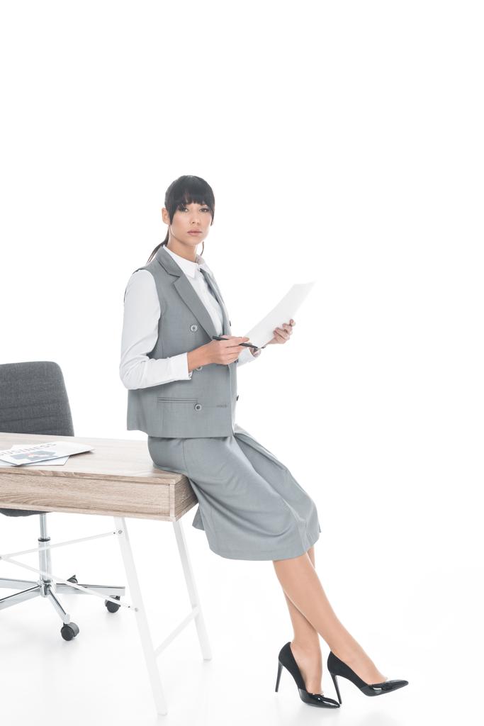 zakenvrouw leunend op tafel en het bedrijf documenten geïsoleerd op wit  - Foto, afbeelding