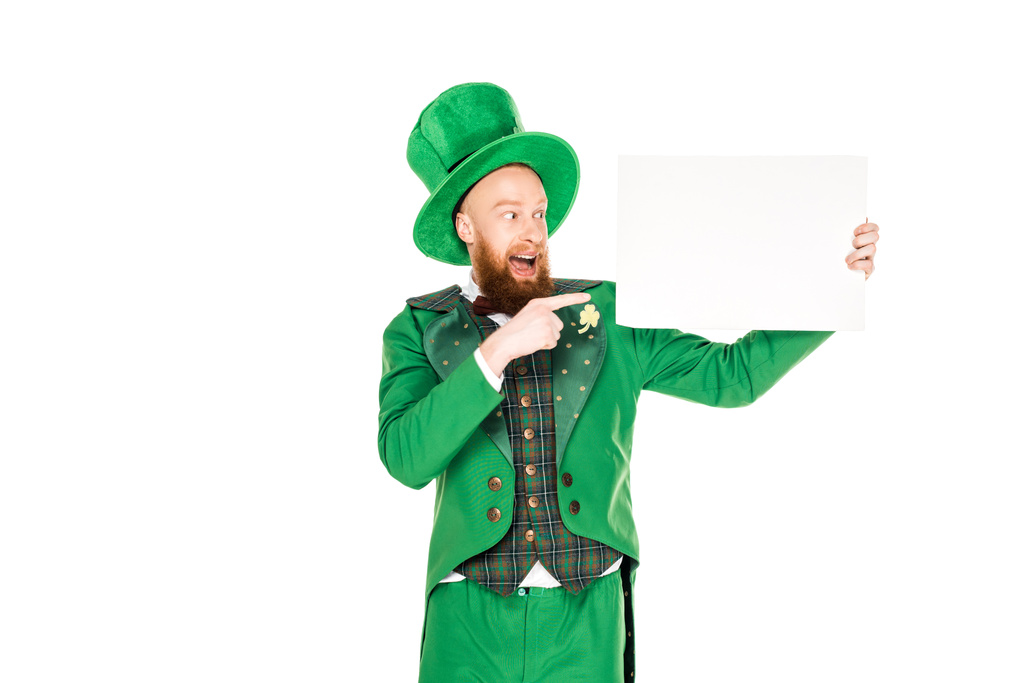 leprechaun in green suit pointing at blank placard, isolated on white - Photo, Image