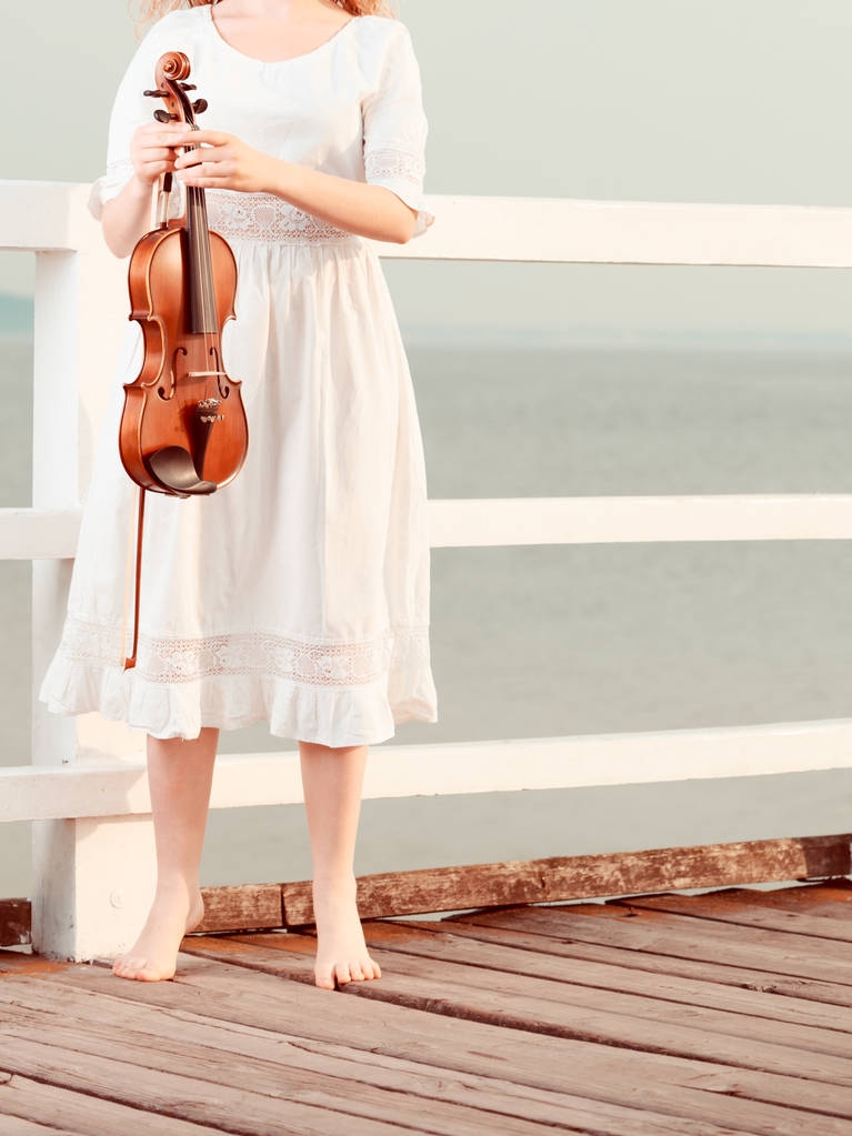 Mujer en muelle afuera sosteniendo violín
 - Foto, Imagen