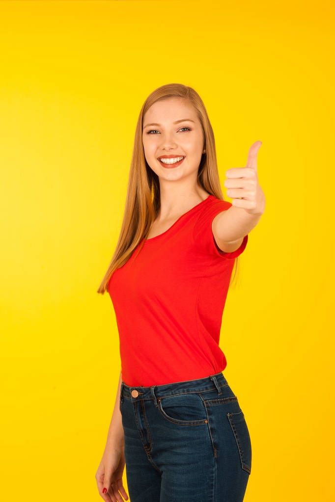 Belle jeune femme en t-shirt rouge sur fond jaune spectacle
 - Photo, image