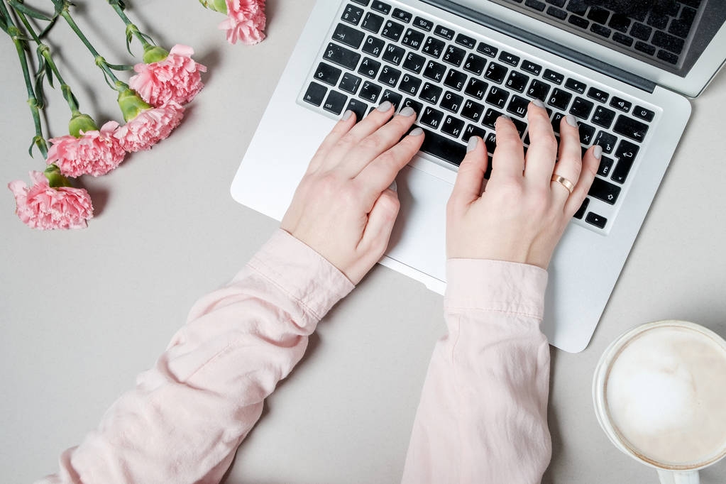 Nő kezet kávé és laptop, szegfű, fehér virágok  - Fotó, kép
