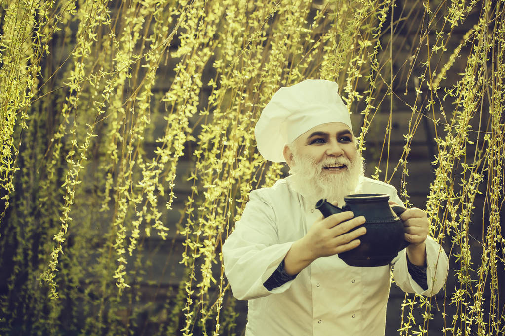 cocinero barbudo con hervidor de té de hierro
 - Foto, imagen