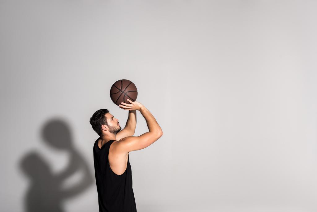 Beyaz basketbol oynarken atletik genç sporcu yan görünüm - Fotoğraf, Görsel