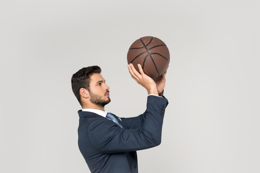 a fiatal üzletember elszigetelt szürke kosárlabda labda dobás oldalnézete - Fotó, kép