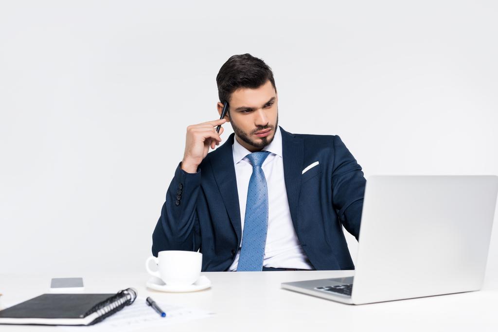 jeune homme d'affaires concentré utilisant ordinateur portable sur le lieu de travail sur gris
 - Photo, image