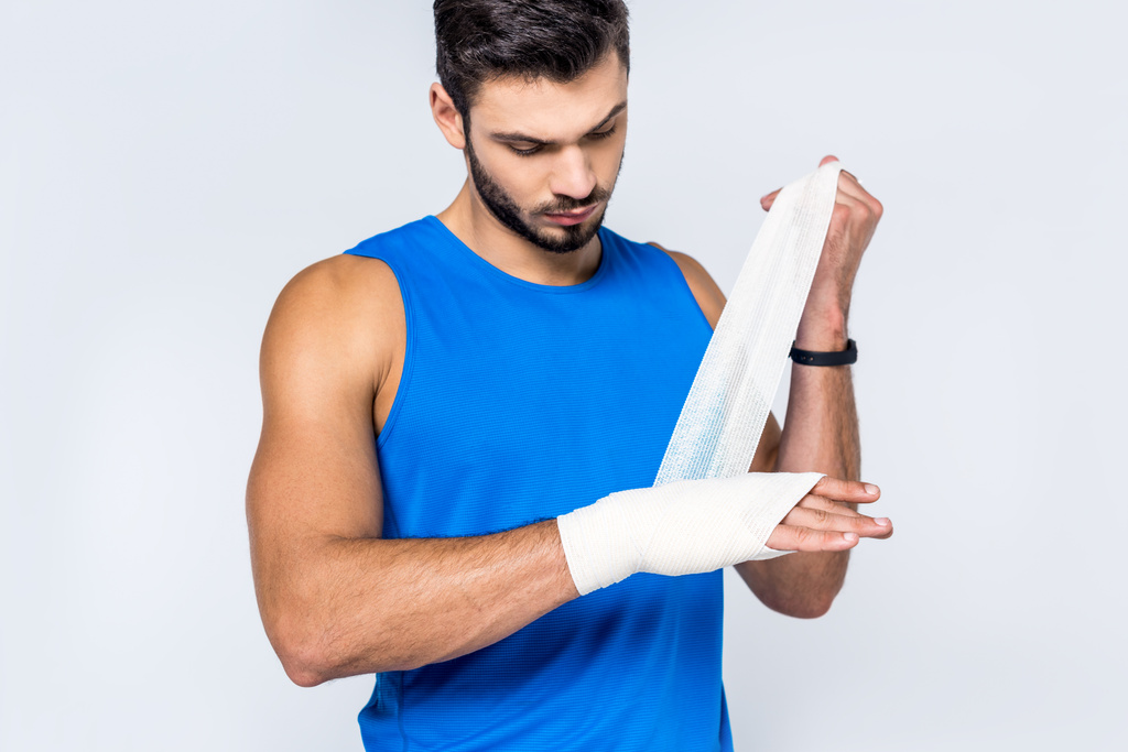 jeune homme couvrant poignet avec bandage isolé sur blanc
 - Photo, image
