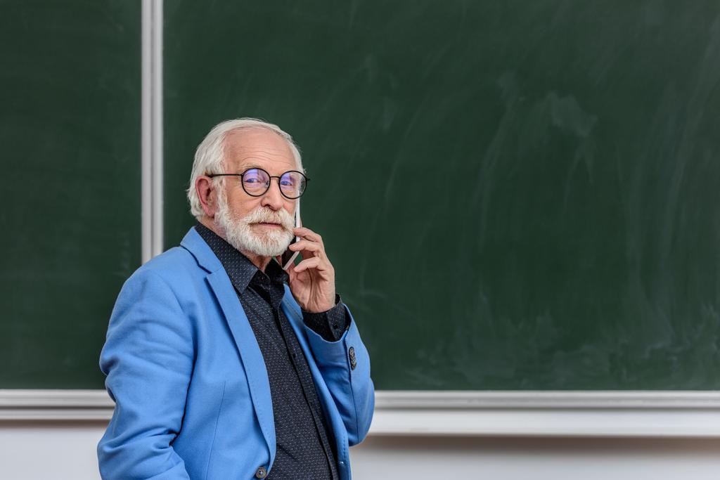 grey hair professor talking by smartphone and looking at camera - Photo, Image