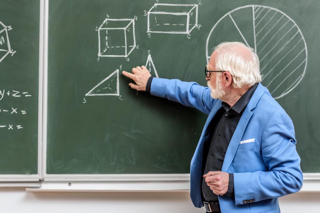 grey hair professor pointing on something with finger at blackboard - Photo, Image