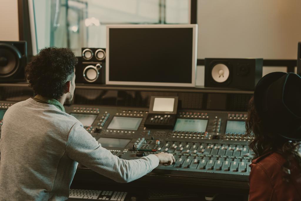 sound producers looking at blank monitor at recording studio - Photo, Image